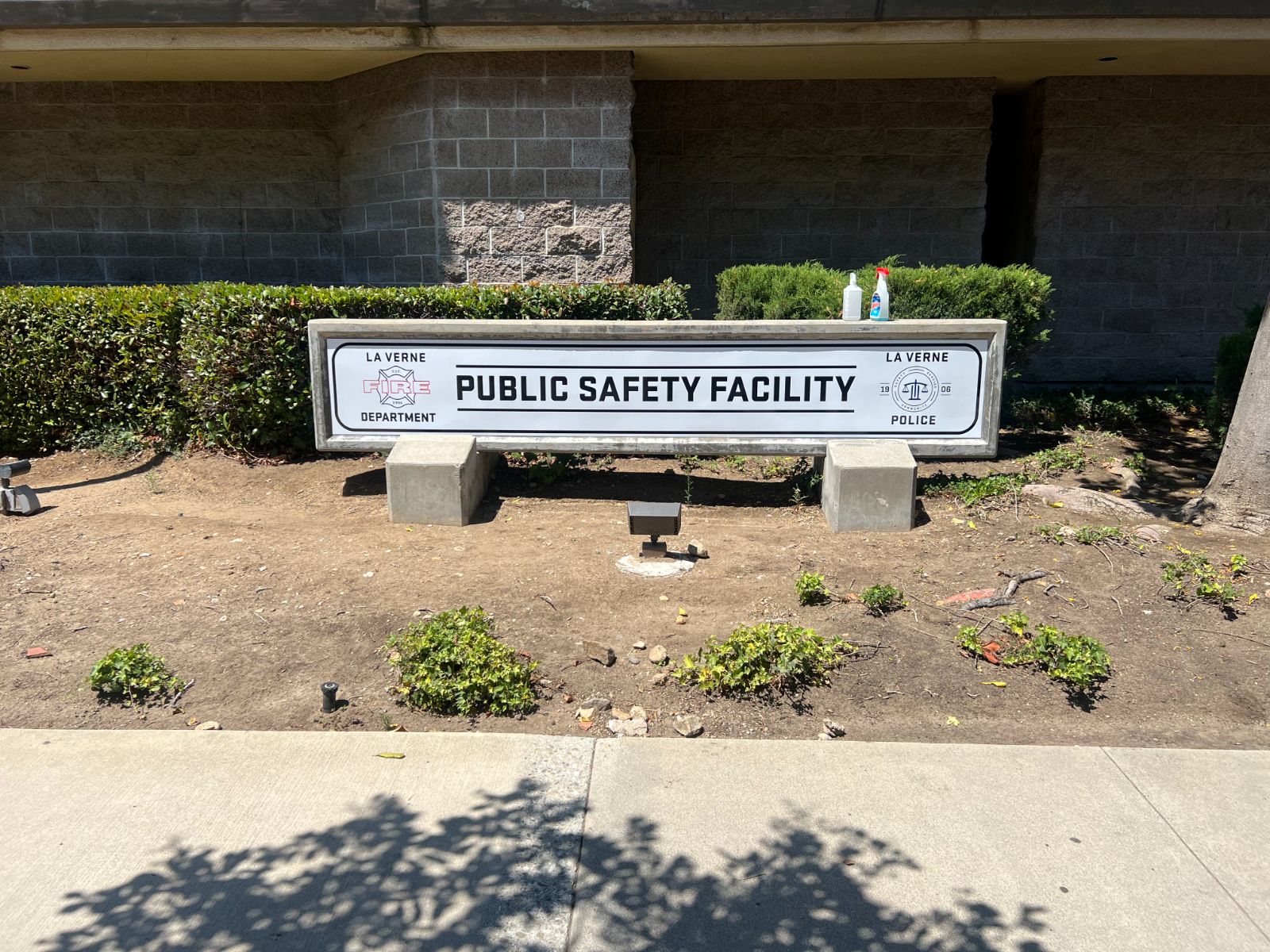 Facility monument sign in La Verne: 'Public Safety Facility' in black text on a concrete base, with a La Verne Fire Department crest and La Verne Police seal, built and installed by Hi Sign