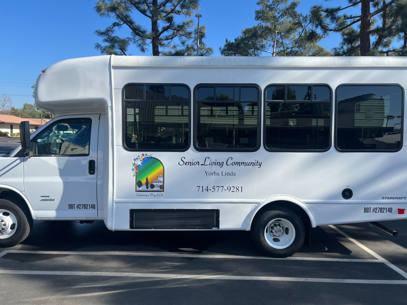 White Starcraft shuttle bus with printed vinyl logo and die-cut lettering on the body panel